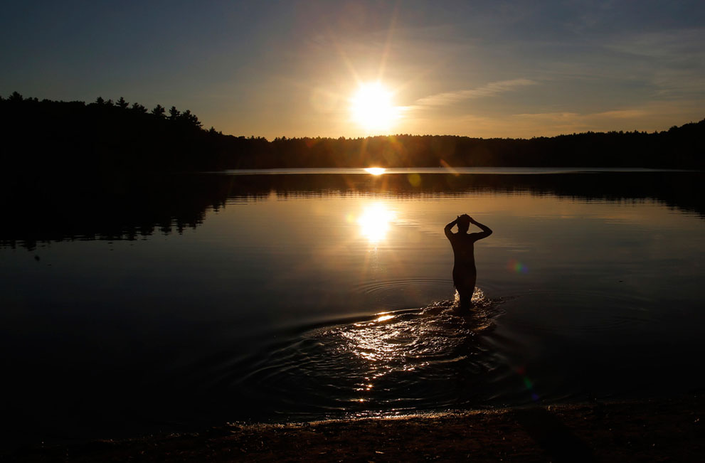 Một người đi bơi bắt đầu tiến xuống làn nước ở hồ Walden, vào một buổi chiều mùa Thu ở Concord, Masachusetts, 15/10/2013.