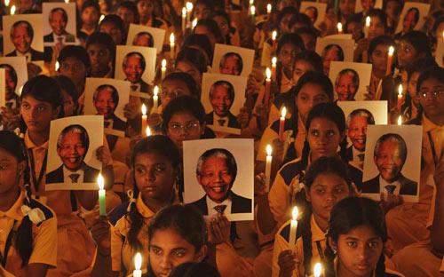 Học sinh Ấn Độ thắp nến và di ảnh của cựu Tổng thống Nam Phi Mandela trong lễ cầu nguyện cho ông tại một trường học ở Ahmadabad.