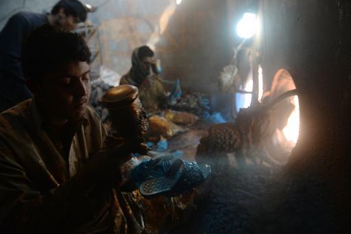 Công nhân Afghanistan sơn giày được làm từ nhựa tái chế ở Kabul