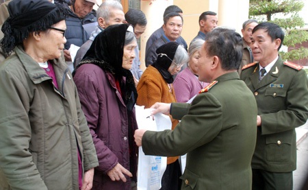 Đại tá Nguyễn Hồng Thái, Phó Tổng biên tập Báo CAND tặng quà nhân dân nghèo thị xã Hoàng Mai.