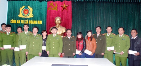 Đại tá Nguyễn Hồng Thái, Phó Tổng biên tập Báo CAND tặng quà CBCS Công an thị xã Hoàng Mai có hoàn cảnh khó khăn, hoàn thành xuất sắc nhiệm vụ.