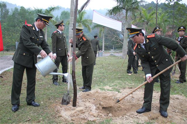 Đồng chí Nguyễn Xuân Lâm - GĐ Công an tỉnh tưới nước cho cây non vừa được trồng