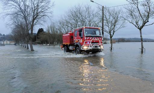 Một chiếc xe cứu hỏa đi qua một đường phố bị ngập lụt ở Redon, Brittany
