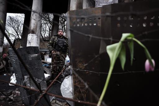 Một người biểu tình nhìn một chướng ngại vật trên Quảng trường Độc lập tại Kiev