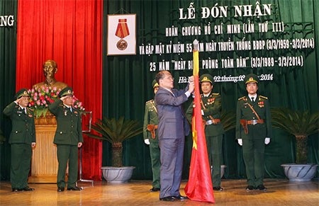 Chủ tịch Quốc hội Nguyễn Sinh Hùng gắn Huân chương Hồ Chí Minh lên Quân kỳ Quyết Thắng của Bộ đội Biên phòng. Ảnh Qđnd.vn