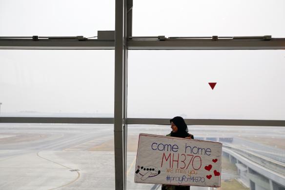 Một phụ nữ mang tấm biển: Hãy trở về nhà MH370, chúng tôi nhớ các bạn!