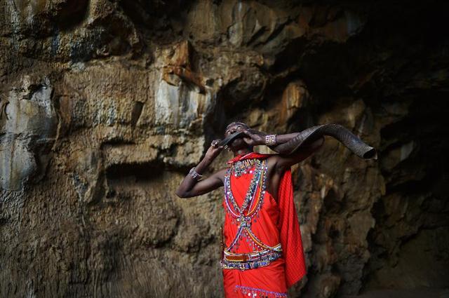 Một người Maasai trẻ thổi tù và bằng sừng trong một hang động ở Suswa, Kenya