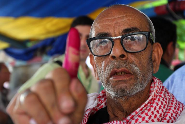 Một người Ai Cập giơ ngón tay vừa điểm chỉ bằng mực sau khi bỏ phiếu trong cuộc bầu cử tổng thống