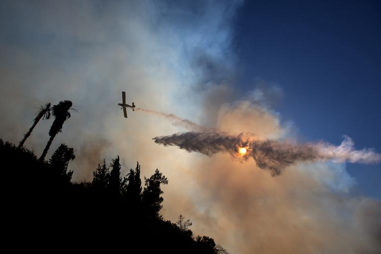 Một chiếc máy bay thả nước từ trên bầu trời trong một nỗ lực để kiểm soát đám cháy rừng gần ngôi làng cổ Ein Kerem, Jerusalem