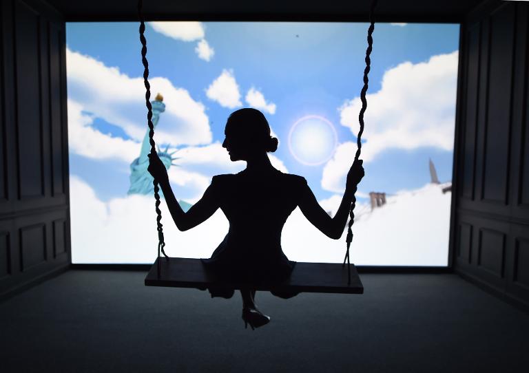 Một người phụ nữ giang tay ra như đôi cánh trước một màn hình đang hiển thị bầu trời New York trong triển lãm Air France ở New York