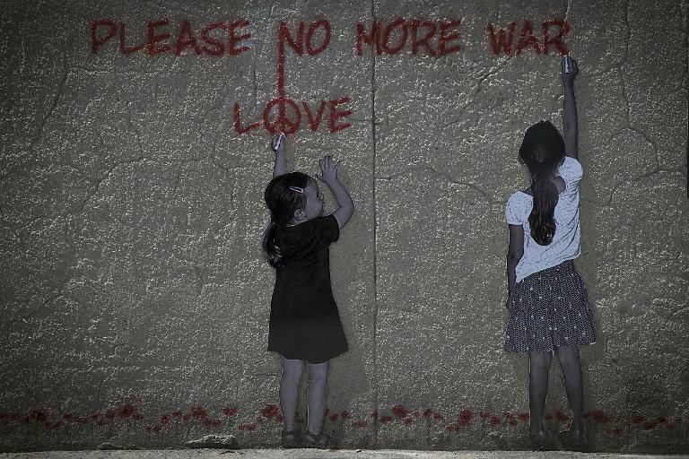 Hình vẽ graffiti miêu tả hai bé gái đang viết dòng chữ 'Please, no more war' trên một bức tường ở Arromanches, Normandy