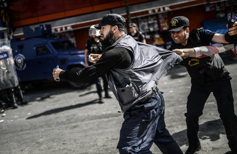 Cảnh sát Thổ Nhĩ Kỳ đang cố ngắn một người Kurd tham gia biểu tình ở huyện Bagcilar, Istanbul với một con dao trong tay