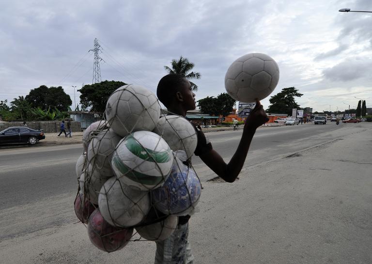 Người đàn ông bán những quá bóng dá trong khu vực Koumassi của Abidjan, Bờ Biển Ngà