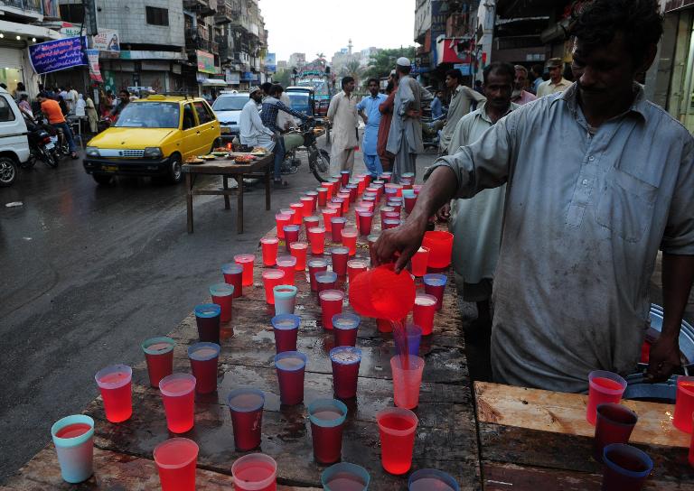 Một người đàn ông Pakistan sắp xếp đồ uống cho các tín đồ Hồi giáo trong tháng thánh lễ Ramadan trên đường phố ở Karachi, Pakistan