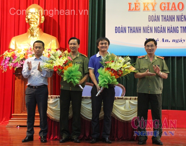 Thiếu tướng Nguyễn Xuân Lâm – Giám đốc công an tỉnh; ông Hoàng Việt Hùng – Giám đốc Ngân hàng BIDV Nghệ An tặng hoa tại lễ ký kết