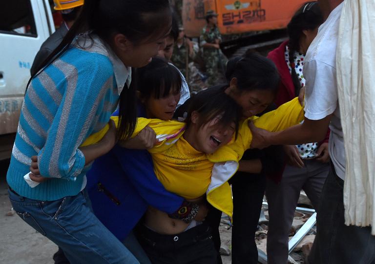 Người phụ nữ trẻ than khóc khi thi thể đứa con nhỏ được tìm thấy trong một tòa nhà bị sập ở Longtoushan, ở phía tây nam tỉnh Vân Nam của Trung Quốc sau vụ động đất kinh hoàng