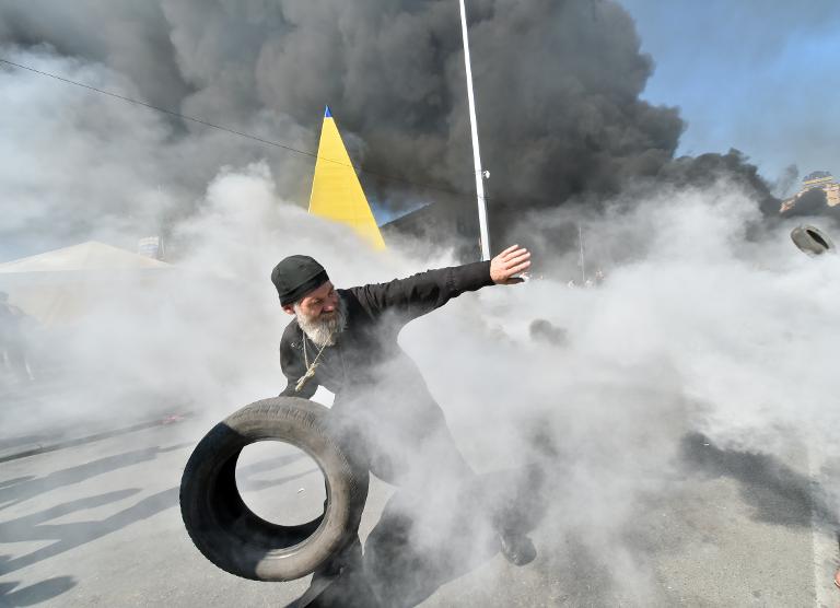 Người biểu tình ném lốp xe vào các đám cháy trong cuộc biểu tình ở Quảng trường Độc lập tại Kiev