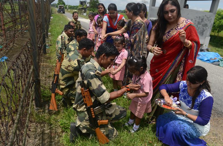 Các bé gái Ấn Độ đeo vòng tay cho những người lính, nghi thức chuẩn bị cho lễ hội của người Hindu gần Siliguri, giáp biên giới với Bangladesh