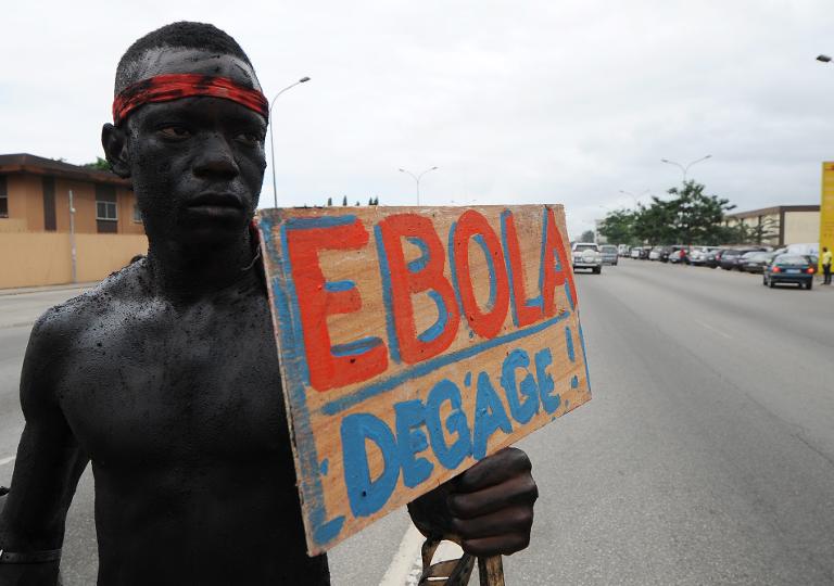 Một thành viên của nhóm nghệ sĩ 'Be Kok Spirit' 'diễu hành ở Abidjian, Bờ Biển Ngà cùng tấm biển ghi dòng chữ 'Ebola, hãy buông tha' để nâng cao nhận thức về virus Ebola