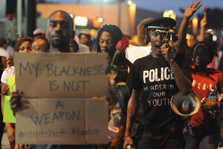 Những người biểu tình ở Ferguson, Missouri, Mỹ mang biểu ngữ thể hiện sự giận dữ sau vụ một cảnh sát da trắng bắn chết một thanh niên da đen trên đường phố