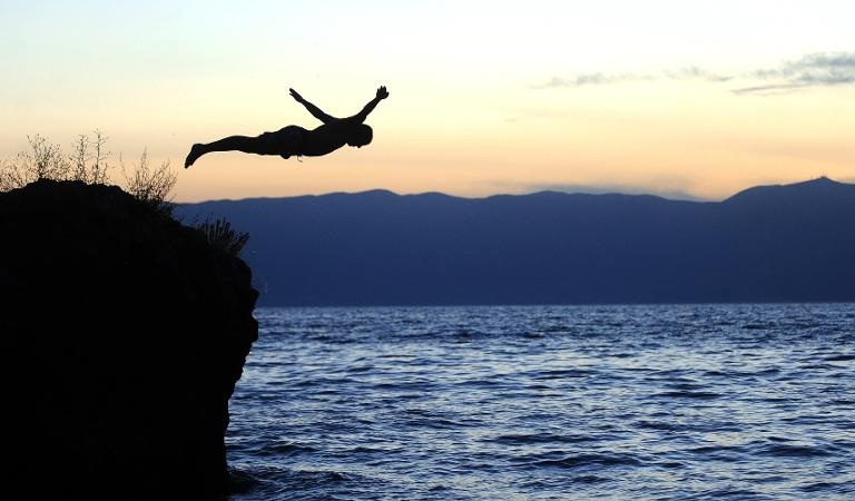 Hình ảnh người đàn ông nhảy từ một tảng đá tại hồ Ohrid ở Ohrid, Macedonia