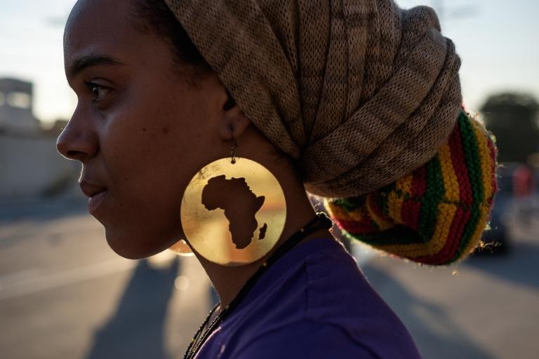 Một người biểu tình đeo bông tai bản đồ châu Phi tham gia Ngày quốc tế chống diệt chủng của người da đen tại Rio de Janeiro, Brazil