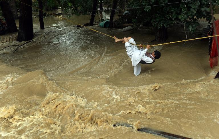 Một người đàn ông Ấn Độ vượt qua nước lũ bằng một sợi dây thừng ở Srinagar, Bang Kashmir, Ấn Độ