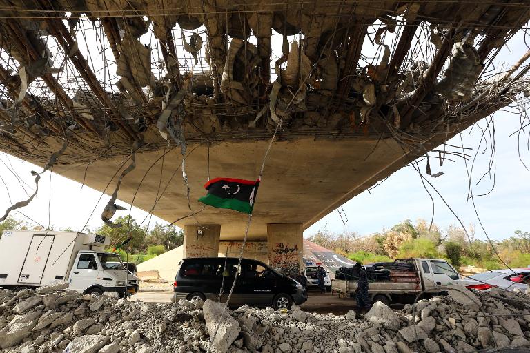 Những chiếc xe hơi dừng trước một trạm kiểm soát dưới chân cầu, phía tây của thủ đô Tripoli nơi đã từng diễn ra cuộc đụng độ ác liệt giữa quân chính phủ và phe nổi dậy