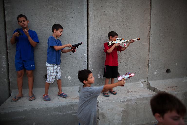 Những đứa trẻ Israel chơi trò chiến tranh giả với súng đồ chơi tại Kibbutz Nahal Oz, Dải Gaza