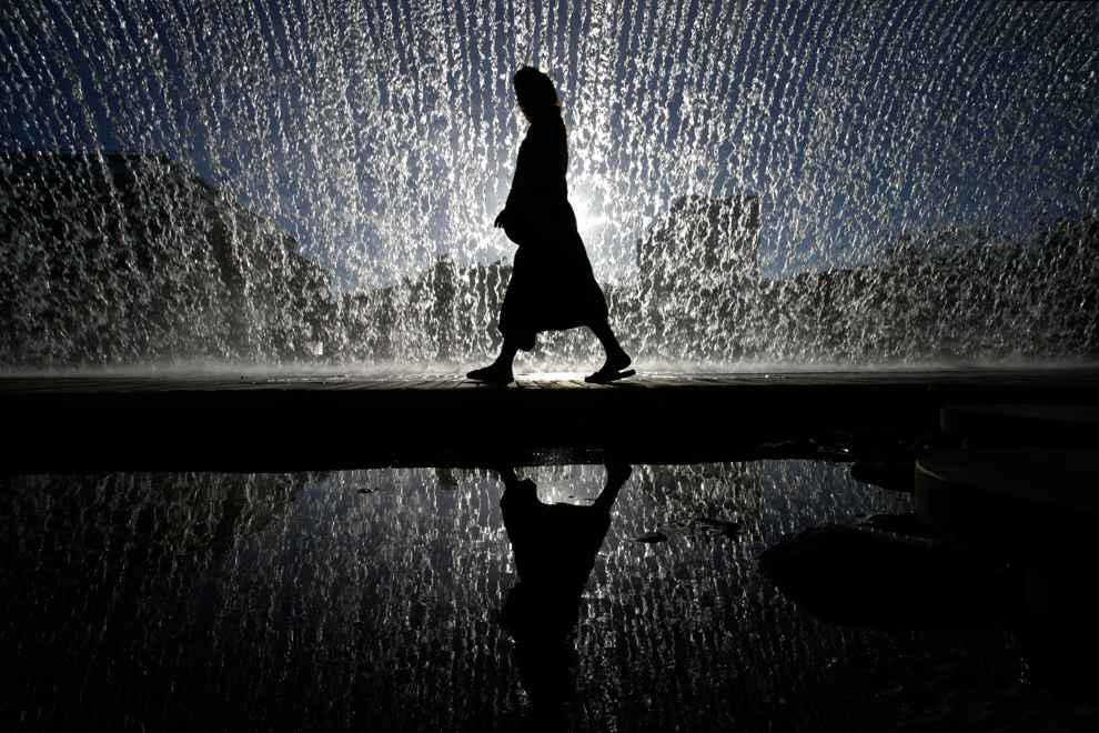 Một người phụ nữ đi bên dưới thác nước nhân tạo ở khu Oceanarium, Lisbon, Bồ Đào Nha