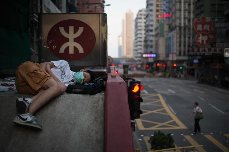 Một người biểu tình đang ngủ trên mái nhà của một ga tàu điện ngầm ở Hồng Kông