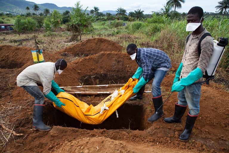Các tình nguyện viên trong trang phục bảo vệ tiến hành chôn cất một nạn nhân tử vong vì Ebola tại  Waterloo, Sierra Leone, một quốc gia ở Tây Phi