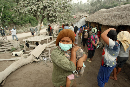 Người dân trang bị khẩu trang để chống lại tro bụi của núi lửa Sinabung đã phun trào mấy ngày trước ở Bắc Sumatra, Indonesia khiến hàng trăm gia đình phải rời bỏ nhà cửa đi nơi khác