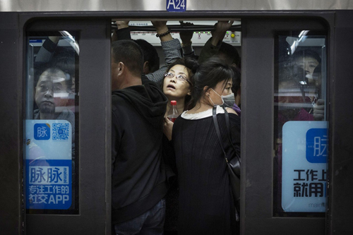 Hành khách chen lấn trong một chuyến tàu điện ngầm vào giờ cao điểm tại Bắc Kinh, Trung Quốc
