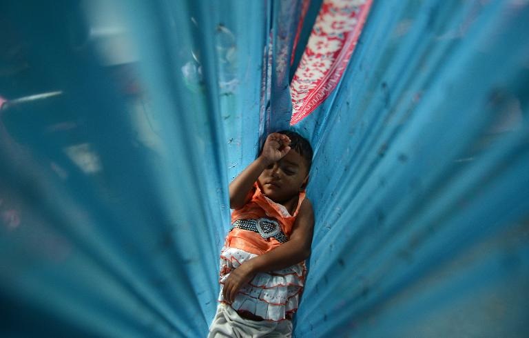 Em bé Sri Lanka, nạn nhân của một vụ lở đất đang nằm trong chiếc võng ở một trại cứu trợ của chính phủ, tại Poonagalla