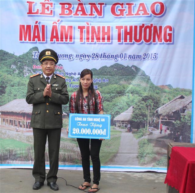 Đại tá Hồ Văn Tứ, Phó giám đốc Công an tỉnh trao tiền hỗ trợ xây dựng ngôi nhà Mái ấm tình thương cho chị Khương