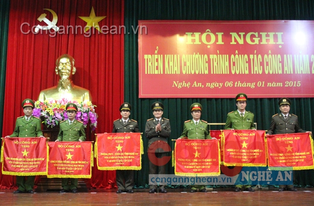 Công an huyện Anh Sơn (ngoài cùng bên trái) nhận Cờ “Đơn vị dẫn đầu phong trào thi đua Vì an ninh Tổ quốc cấp cơ sở năm 2014” của Bộ Công an