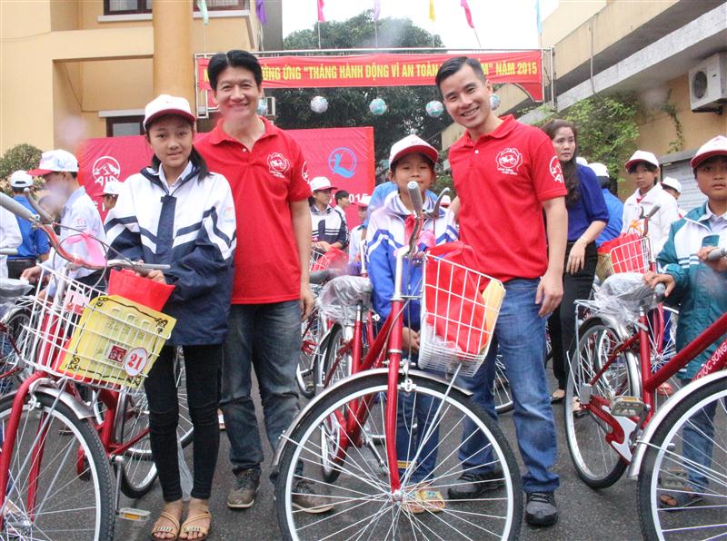 Ông Lý Thành Nhơn và ông Võ Quyết Thắng, Phó Tổng Giám đốc AIA Việt Nam trao tặng xe đạp cho các cháu