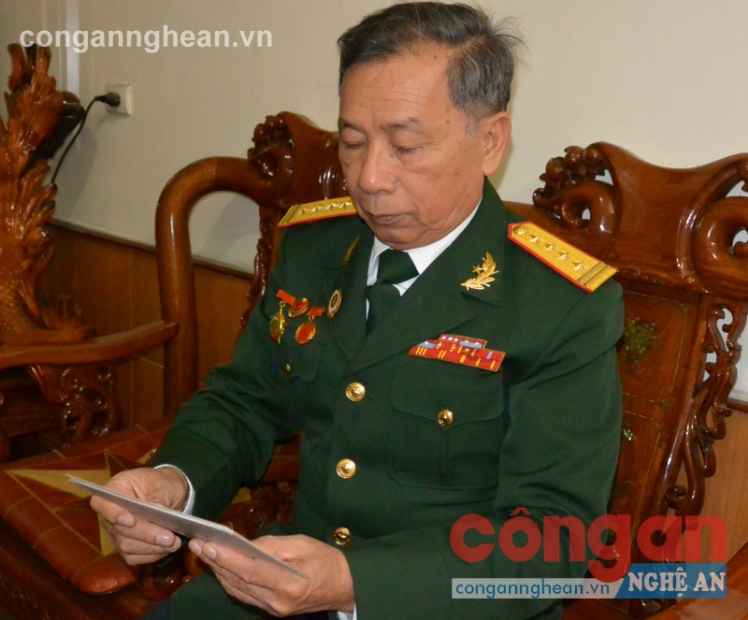 Đại tá Nguyễn Văn Thực  xem lại những bức ảnh chụp ở chiến trường