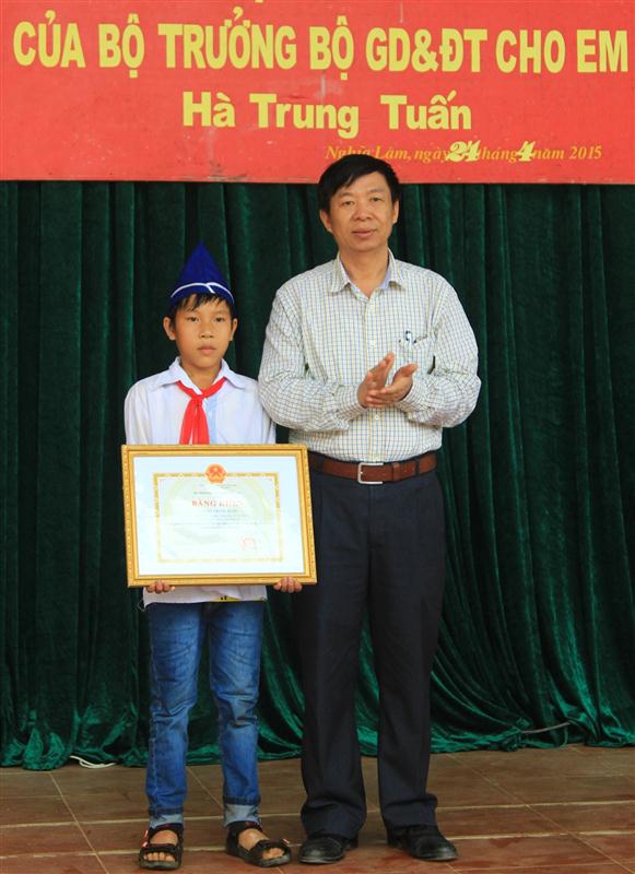 Thừa uỷ quyền của  Bộ trưởng Bộ GD&ĐT,  ông Nguyễn Hoàng, Phó Giám đốc Sở GD&ĐT Nghệ An  trao Bằng khen  cho em Hà Trung Tuấn