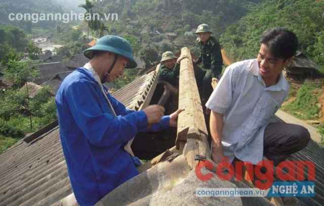 Bộ đội biên phòng, Dân quân tự vệ xã Hạnh Dịch, huyện Quế Phong giúp người dân sửa nhà  bị lốc xoáy làm hư hỏng