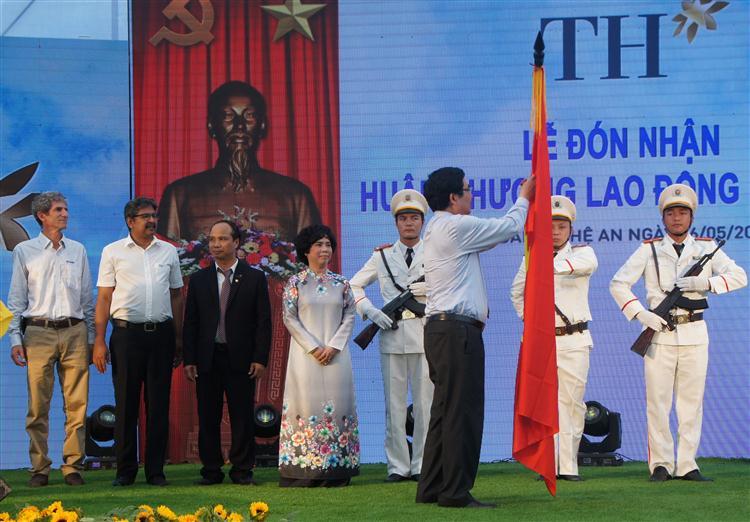 Bộ trưởng Bộ NN&PTNT Cao Đức Phát gắn Huân chương lao động Hạng Ba lên lá cờ truyền thống của tập đoàn TH.