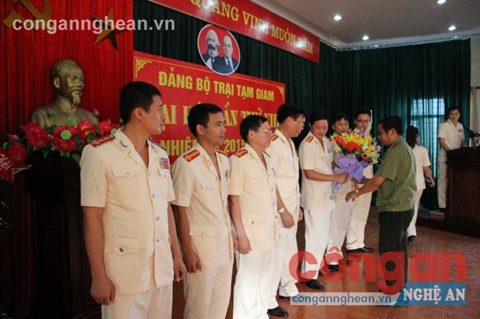 Đồng chí Đại tá Trần Minh Bình, Trưởng phòng Công tác Đảng và công tác quần chúng              tặng hoa chúc mừng BCH Đảng bộ Trại tạm giam Công an tỉnh nhiệm kỳ mới  