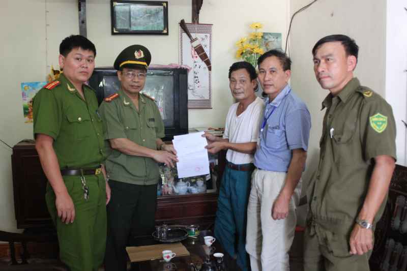 Đại tá Bùi Văn Ngân - Trưởng phòng xây dựng phong trào toàn dân bảo bệ ANTQ trao quà cho ông Cao Ngọc Ký