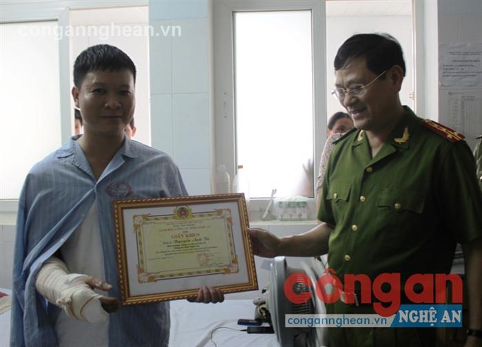 Đại tá Nguyễn Hữu Cầu, Giám đốc Công an tỉnh trao Giấy khen cho đồng chí Tú