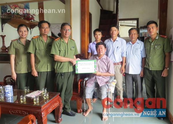 Đại diện lãnh đạo Phòng Kỹ thuật Nghiệp vụ II và chính quyền địa phương trao quà cho thương bệnh binh Phan Bá Mỡn