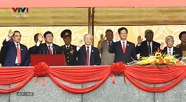 Trên lễ đài, các đồng chí lãnh đạo Đảng, Nhà nước vẫy chào đoàn diễu binh.
