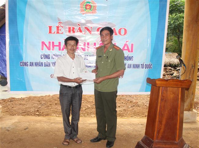 Đồng chí Đại tá Phan Đình Sửu, Trưởng phòng An ninh xã hội trao quà cho gia đình đồng chí Vi Văn Oanh