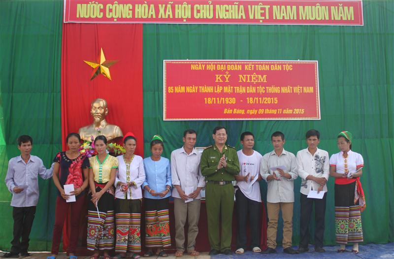 Thay mặt Tỉnh uỷ, HĐND, UBND, UBMTTQ tỉnh, Đại tá Nguyễn Hữu Cầu tặng quà cho các gia đình chính sách bản Bàng