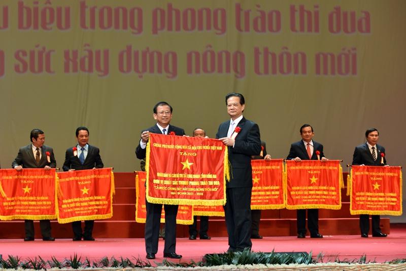 Thủ tướng Nguyễn Tấn Dũng trao Cờ thi đua của Chính phủ cho 10 huyện đạt chuẩn nông thôn mới. Ảnh: VGP/Nhật Bắc
